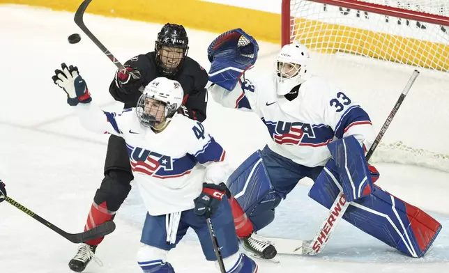 Canada's Laura Stacey, top left, tries to tip the puck in front of United States goaltender Gwyneth Philips, right, and Sydney Bard during the first period of a women's Rivalry Series hockey game in Halifax, Nova Scotia, Thursday, Feb. 6, 2025. (Darren Calabrese/The Canadian Press via AP)