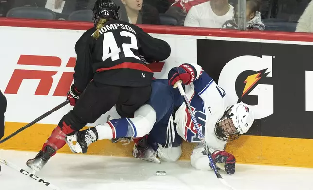 Canada's Claire Thompson, left, knocks down USA's Britta Curl-Salemme during the first period of a women's Rivalry Series hockey game in Halifax, Nova Scotia, Thursday, Feb. 6, 2025. (Darren Calabrese/The Canadian Press via AP)