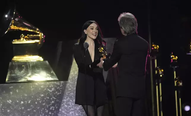 St. Vincent, left, accepts the award for best alternative music album for "All Born Screaming" from Bob Clearmountain during the 67th annual Grammy Awards on Sunday, Feb. 2, 2025, in Los Angeles. (AP Photo/Chris Pizzello)