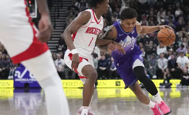 Utah Jazz guard Keyonte George (3) dribbles past Houston Rockets forward Amen Thompson (1) during the first half of an NBA basketball game Saturday, Feb. 22, 2025, in Salt Lake City. (AP Photo/Bethany Baker)