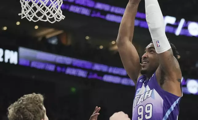 Utah Jazz forward KJ Martin (99) dunks the ball as Utah Jazz forward Lauri Markkanen (23) looks on during the first half of an NBA basketball game against the Houston Rockets Saturday, Feb. 22, 2025, in Salt Lake City. (AP Photo/Bethany Baker)