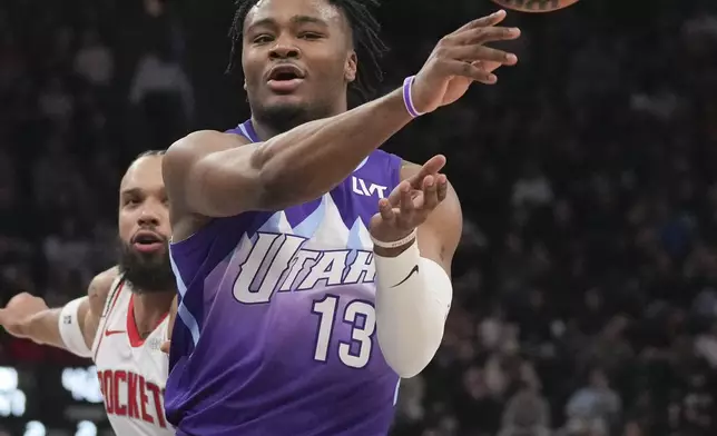 Utah Jazz guard Isaiah Collier (13) passes the ball as Houston Rockets forward Dillon Brooks, left,defends during the first half of an NBA basketball game Saturday, Feb. 22, 2025, in Salt Lake City. (AP Photo/Bethany Baker)