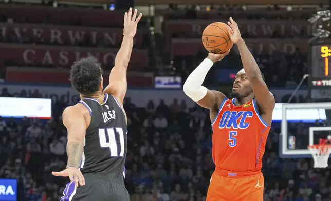 Oklahoma City Thunder guard Luguentz Dort (5) shoots over Sacramento Kings forward Trey Lyles (41) during the second half of an NBA basketball game, Saturday, Feb. 1, 2025, in Oklahoma City. (AP Photo/Kyle Phillips)