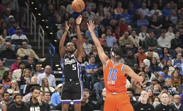 Sacramento Kings guard De'Aaron Fox (5) shoots over Oklahoma City Thunder forward Ousmane Dieng (13) during the first half of an NBA basketball game, Saturday, Feb. 1, 2025, in Oklahoma City. (AP Photo/Kyle Phillips)