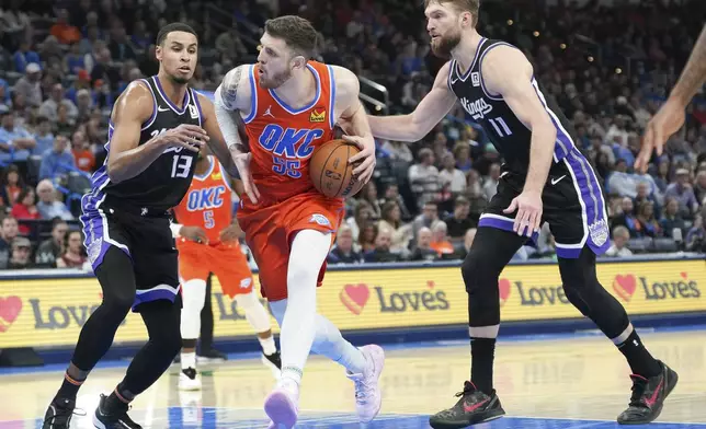 Oklahoma City Thunder center Isaiah Hartenstein (55) drives past Sacramento Kings forwards Keegan Murray (13) and Domantas Sabonis (11) during the second half of an NBA basketball game, Saturday, Feb. 1, 2025, in Oklahoma City. (AP Photo/Kyle Phillips)