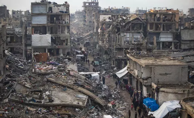 Palestinians walk in the destruction caused by the Israeli air and ground offensive in Jabaliya, Gaza Strip, Tuesday, Feb. 11, 2025. (AP Photo/Jehad Alshrafi)