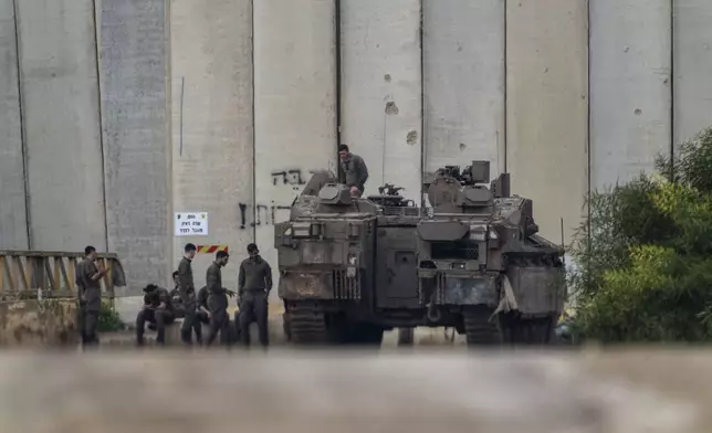 Israeli soldiers gather by the border with the Gaza Strip, in southern Israel, Tuesday, Feb.11, 2025. (AP Photo/Ariel Schalit)
