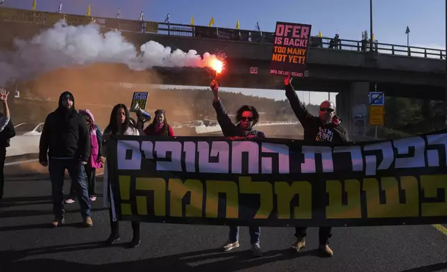 Relatives of hostages held by Hamas in the Gaza Strip block a highway between Jerusalem and Tel Aviv a day after the militant group announced it would delay a planned hostage release after accusing Israel of violating a fragile ceasefire. Tuesday, Feb. 11, 2025. (AP Photo/Ohad Zwigenberg)