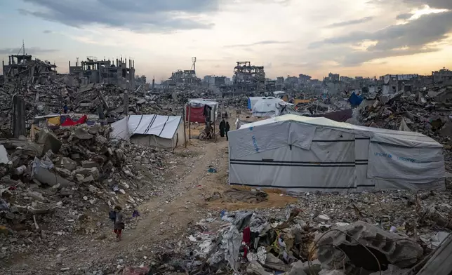 Palestinians walk in the destruction caused by the Israeli air and ground offensive in Jabaliya, Gaza Strip, Tuesday, Feb. 11, 2025. (AP Photo/Jehad Alshrafi)