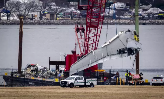 Salvage crews work near the wreckage site in the Potomac River of a mid-air collision between an American Airlines jet and a Black Hawk helicopter, at Ronald Reagan Washington National Airport, Wednesday, Feb. 5, 2025, in Arlington, Va. (AP Photo/Ben Curtis)