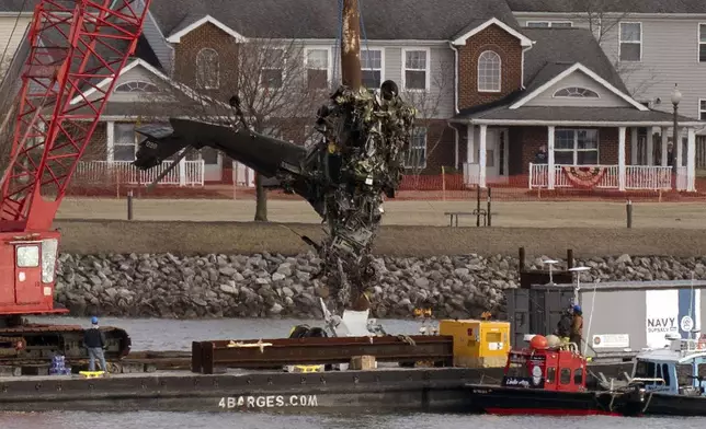 Salvage crews pull up a part of a Black Hawk helicopter near the site in the Potomac River of a mid-air collision between an American Airlines jet and a Black Hawk helicopter at Ronald Reagan Washington National Airport, Thursday, Feb. 6, 2025, in Arlington, Va. (AP Photo/Jose Luis Magana)