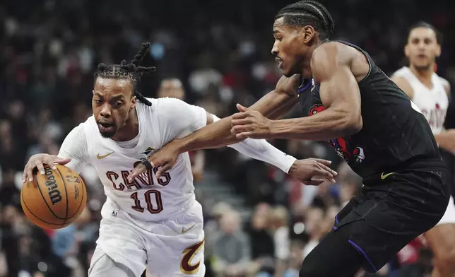 Cleveland Cavaliers' Darius Garland (10) drives past Toronto Raptors' Ochai Agbaji (30) during the first half of an NBA basketball game in Toronto on Wednesday, Feb. 12, 2025. (Frank Gunn/The Canadian Press via AP)