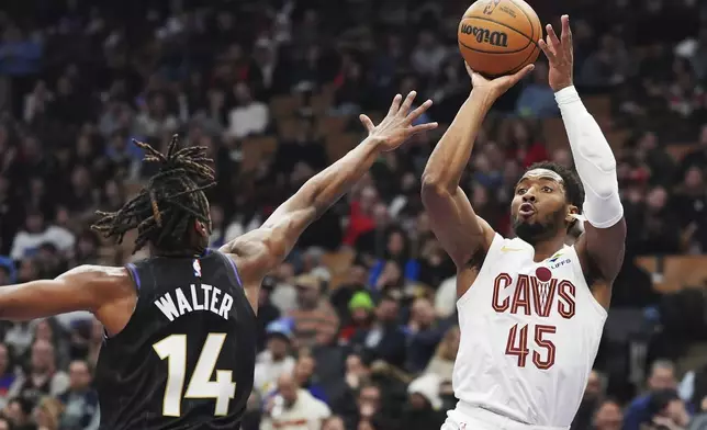 Cleveland Cavaliers' Donovan Mitchell (45) shoots over Toronto Raptors' Ja'Kobe Walter (14) during the first half of an NBA basketball game in Toronto on Wednesday, Feb. 12, 2025. (Frank Gunn/The Canadian Press via AP)
