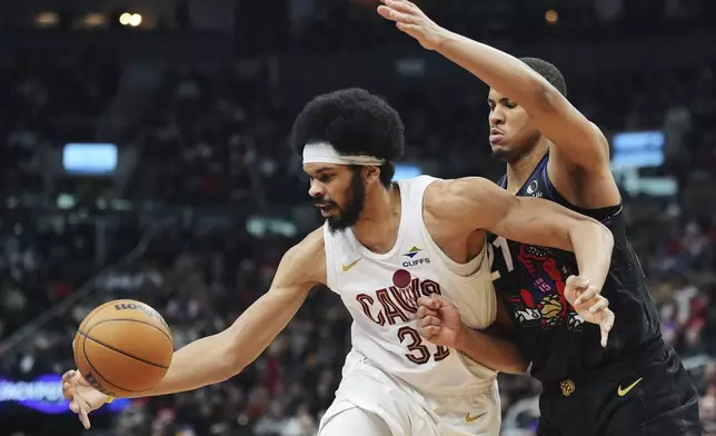 Cleveland Cavaliers' Jarrett Allen, left, protects the ball from Toronto Raptors' Orlando Robinson during the first half of an NBA basketball game in Toronto on Wednesday, Feb. 12, 2025. (Frank Gunn/The Canadian Press via AP)