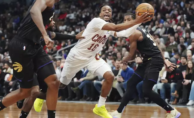Cleveland Cavaliers' Darius Garland (10) drives through the Toronto Raptors defense during the first half of an NBA basketball game in Toronto on Wednesday, Feb. 12, 2025. (Frank Gunn/The Canadian Press via AP)