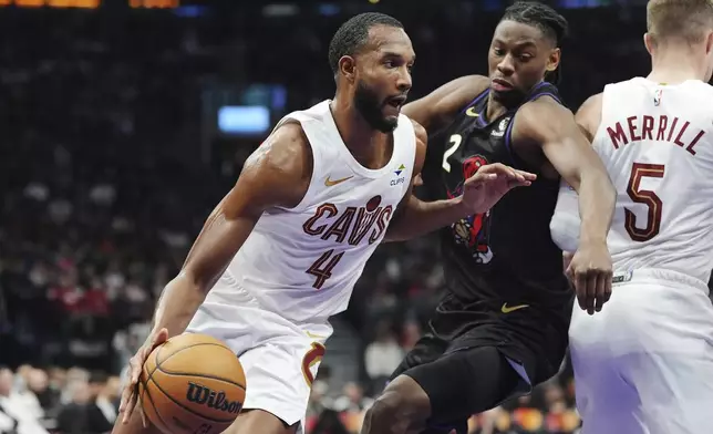 Cleveland Cavaliers' Evan Mobley (4) drives around Toronto Raptors' Jonathan Mogbo (2) during the first half of an NBA basketball game in Toronto, Wednesday, Feb. 12, 2025. (Frank Gunn/The Canadian Press via AP)