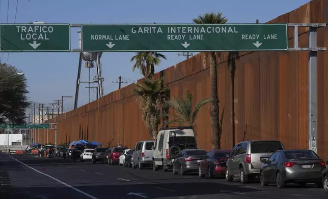 Drivers wait in line to enter to U.S, in Mexicali, Mexico, Saturday, Feb. 1, 2025. (AP Photo/Fernando Llano)