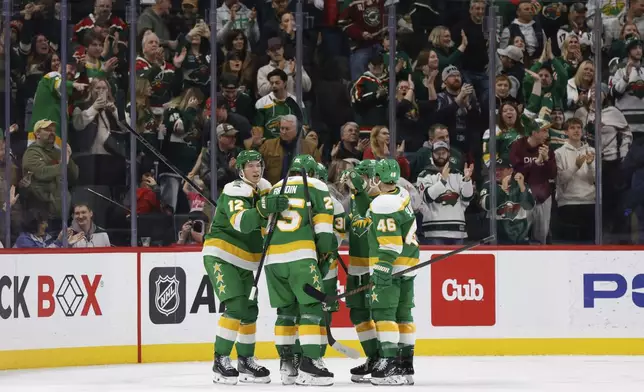 Minnesota Wild left wing Matt Boldy (12) celebrates with teammates after scoring against the New York Islanders during the second period of an NHL hockey game Saturday, Feb. 8, 2025, in St. Paul, Minn. (AP Photo/Bailey Hillesheim)