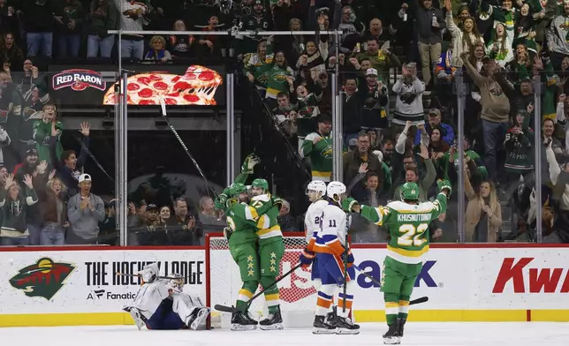 Minnesota Wild center Yakov Trenin, second from the left, celebrates with left wing Marcus Foligno (17) after scoring against the New York Islanders during the second period of an NHL hockey game Saturday, Feb. 8, 2025, in St. Paul, Minn. (AP Photo/Bailey Hillesheim)
