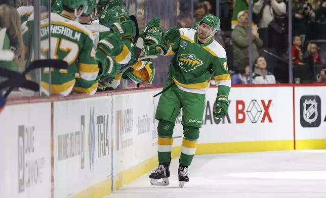 Minnesota Wild center Yakov Trenin (13) is congratulated after scoring against the New York Islanders during the second period of an NHL hockey game Saturday, Feb. 8, 2025, in St. Paul, Minn. (AP Photo/Bailey Hillesheim)