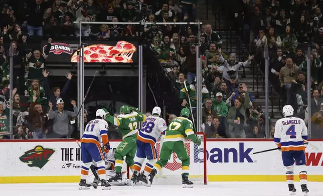 Minnesota Wild center Yakov Trenin, 4th from the right, scores a goal against the New York Islanders during the second period of an NHL hockey game Saturday, Feb. 8, 2025, in St. Paul, Minn. (AP Photo/Bailey Hillesheim)