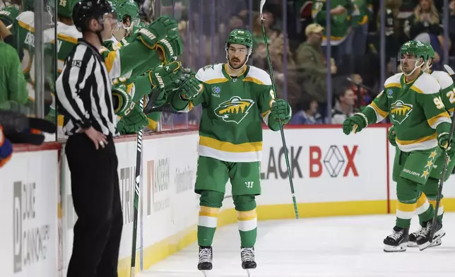 Minnesota Wild center Frederick Gaudreau, center, is congratulated after scoring against the New York Islanders during the second period of an NHL hockey game Saturday, Feb. 8, 2025, in St. Paul, Minn. (AP Photo/Bailey Hillesheim)