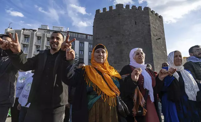 Kurdish people dance as they gather to watch live on a tv screen a Pro-Kurdish Peoples' Equality and Democracy Party, or DEM, delegation members releasing an statement from the jailed leader of the rebel Kurdistan Workers' Party, or PKK, Abdullah Ocalan, in Diyarbakir, Turkey, Thursday, Feb. 27, 2025. (AP Photo/Metin Yoksu)