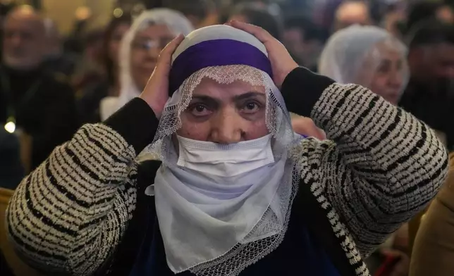 A supporter of Pro-Kurdish Peoples' Equality and Democracy Party, or DEM, gestures as a delegation members release a statement from the jailed leader of the rebel Kurdistan Workers' Party, or PKK, Abdullah Ocalan, in Istanbul, Turkey, Thursday, Feb. 27, 2025. (AP Photo/Khalil Hamra)