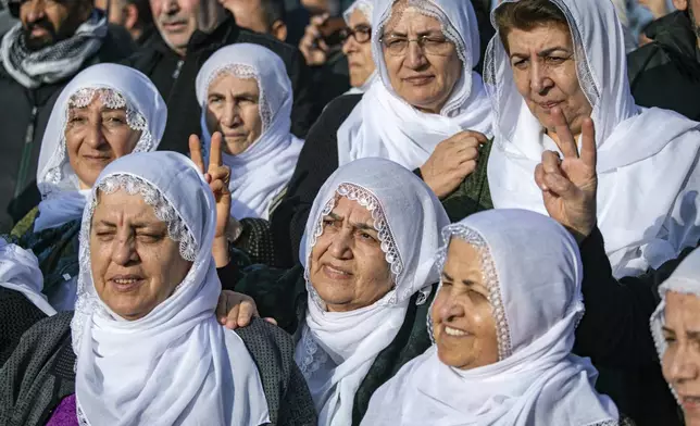 Kurdish women watch live on a tv screen a Pro-Kurdish Peoples' Equality and Democracy Party, or DEM, delegation members releasing an statement from the jailed leader of the rebel Kurdistan Workers' Party, or PKK, Abdullah Ocalan, in Diyarbakir, Turkey, Thursday, Feb. 27, 2025. (AP Photo/Metin Yoksu)