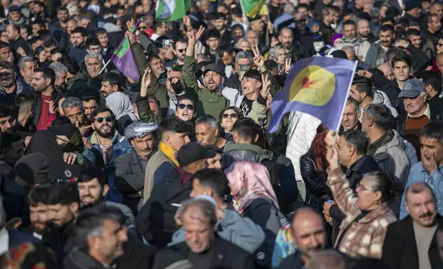 People gather to watch live on a tv screen a Pro-Kurdish Peoples' Equality and Democracy Party, or DEM, delegation members releasing an statement from the jailed leader of the rebel Kurdistan Workers' Party, or PKK, Abdullah Ocalan, in Diyarbakir, Turkey, Thursday, Feb. 27, 2025. (AP Photo/Metin Yoksu)