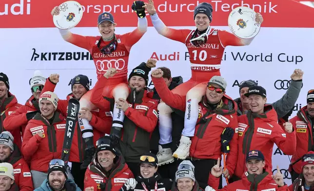 Switzerland's Marco Odermatt, top left, winner of an alpine ski, men's World Cup Super-G, and third-placed Switzerland's Stefan Rogentin, top right, celebrate with the team, in Kitzbuehel, Austria, Friday, Jan. 24, 2025. (AP Photo/Marco Trovati)