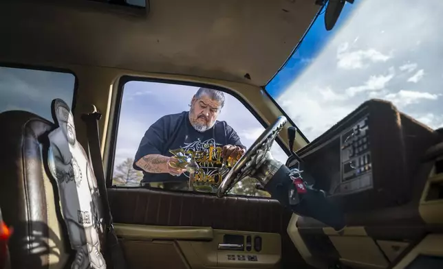Lorenzo Otero polishes a car club emblem on his lowrider truck outside of the State Capitol in Santa Fe, N.M., on Lowrider Day, Tuesday, Feb. 11, 2025. (AP Photo/Roberto E. Rosales)