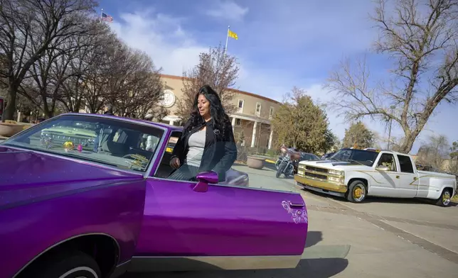 Joan Medina of Chimayo displays her 1987 lowrider Pontiac Grand Prix outside of the State Capitol in Santa Fe, N.M., on Lowrider Day, Tuesday, Feb. 11, 2025. (AP Photo/Roberto E. Rosales)