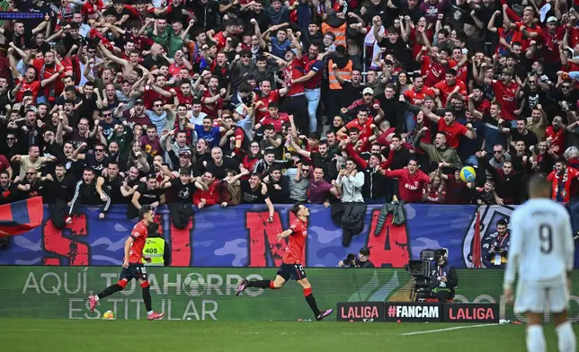 Osasuna's Ante Budimir, centre, celebrates after scoring his side's first goal during a Spanish La Liga soccer match between Osasuna and Real Madrid at El Sardar stadium in Pamplona, Spain, Saturday, Feb. 15, 2025. (AP Photo/Miguel Oses)