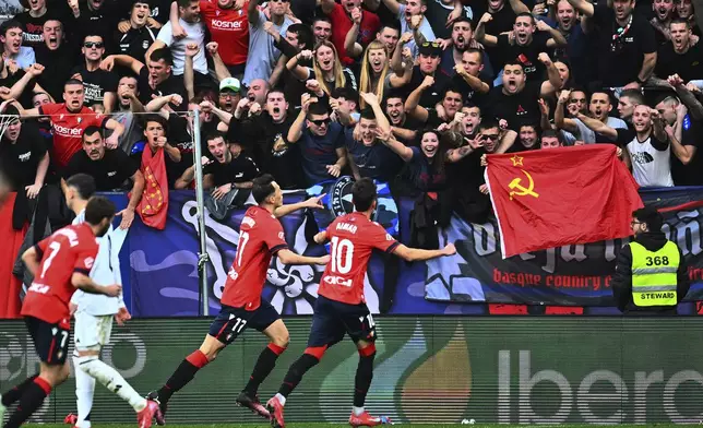 Osasuna's Ante Budimir, centre left, celebrates with Aimar Oroz, right, after scoring his side's first goal during a Spanish La Liga soccer match between Osasuna and Real Madrid at El Sardar stadium in Pamplona, Spain, Saturday, Feb. 15, 2025. (AP Photo/Miguel Oses)