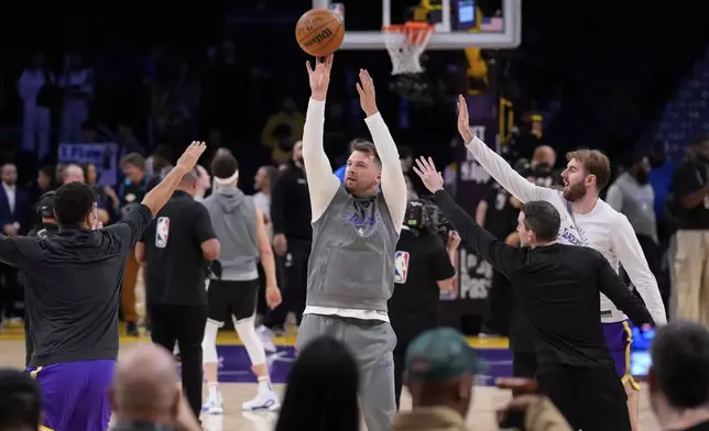 Los Angeles Lakers guard Luka Doncic, center, warms up before an NBA basketball game against the Dallas Mavericks, Tuesday, Feb. 25, 2025, in Los Angeles. (AP Photo/Mark J. Terrill)
