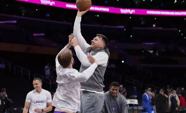 Los Angeles Lakers guard Luka Doncic, center right, warms up before an NBA basketball game against the Dallas Mavericks, Tuesday, Feb. 25, 2025, in Los Angeles. (AP Photo/Mark J. Terrill)