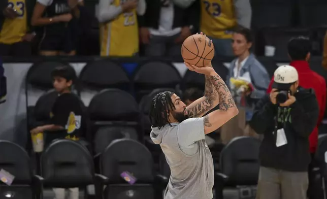 Dallas Mavericks forward Anthony Davis, center, warms up before an NBA basketball game against the Los Angeles Lakers, Tuesday, Feb. 25, 2025, in Los Angeles. (AP Photo/Kyunsung Gong)