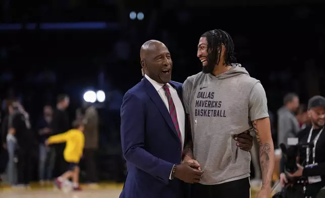 Dallas Mavericks forward Anthony Davis, right, is greeted by former Los Angeles Lakers player James Worthy before an NBA basketball game against the Lakers, Tuesday, Feb. 25, 2025, in Los Angeles. (AP Photo/Mark J. Terrill)