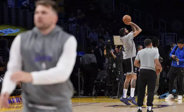 Dallas Mavericks forward Anthony Davis, fourth from right, and Los Angeles Lakers guard Luka Doncic, foreground, warm ups before an NBA basketball game Tuesday, Feb. 25, 2025, in Los Angeles. (AP Photo/Mark J. Terrill)