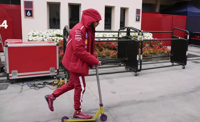 Ferrari driver Lewis Hamilton of Britain rides a scooter during a Formula One pre-season test at the Bahrain International Circuit in Sakhir, Bahrain, Thursday, Feb. 27, 2025. (AP Photo/Darko Bandic)