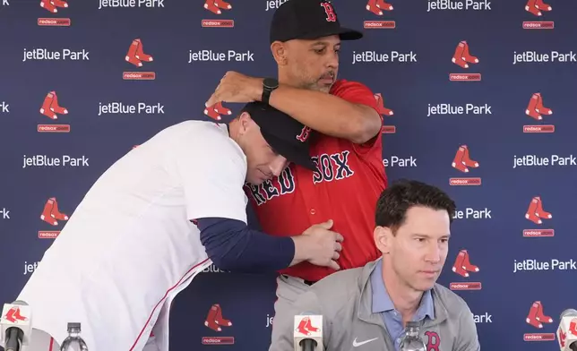 Boston Red Sox manager Alex Cora, right, hugs Alex Bregman at a news conference after Bregman signed a three year contract with the Boston Red Sox in Fort Myers, Fla., Sunday, Feb. 16, 2025. (AP Photo/Gerald Herbert)
