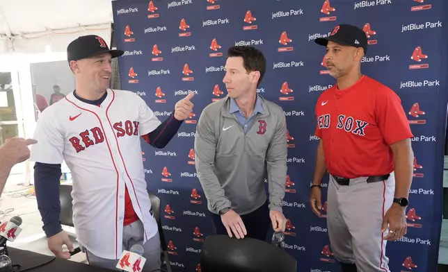Alex Bregman, left, greets media with Craig Breslow, chief baseball officer for the Boston Red Sox, center, and manager Alex Cora, right, at a news conference after signing a three year contract with the Red Sox in Fort Myers, Fla., Sunday, Feb. 16, 2025. (AP Photo/Gerald Herbert)