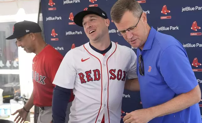 Alex Bregman greets media with Boston Red Sox president and CEO Sam Kennedy, right, and manager Alex Cora, left, at a news conference after signing a three year contract with the Red Sox in Fort Myers, Fla., Sunday, Feb. 16, 2025. (AP Photo/Gerald Herbert)