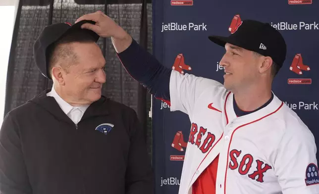 Alex Bregman places a cap on the head of agent Scott Boras at a news conference after he signed a three year contract with the Boston Red Sox in Fort Myers, Fla., Sunday, Feb. 16, 2025. (AP Photo/Gerald Herbert)