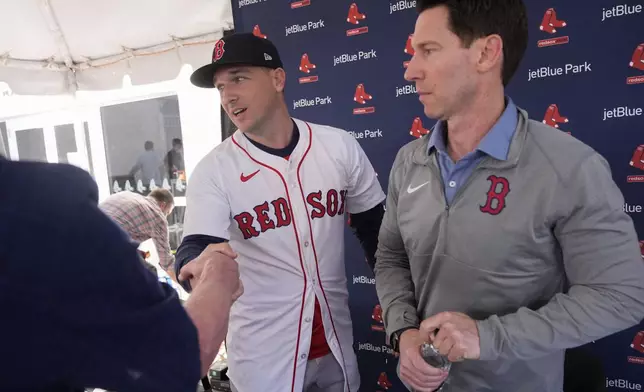 Alex Bregman, left, greets media with Craig Breslow, chief baseball officer for the Boston Red Sox, at a news conference after signing a three year contract with the Red Sox in Fort Myers, Fla., Sunday, Feb. 16, 2025. (AP Photo/Gerald Herbert)