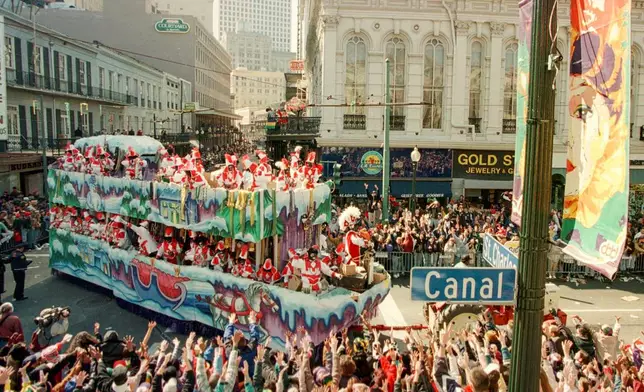 FILE - Mardi Gras revelers greet a float from the Zulu parade at the corner of St. Charles and Canal Streets in New Orleans, La., on Mardi Gras day Tuesday, Feb. 11, 1997. (AP Photo/Andrew J. Cohoon, File)