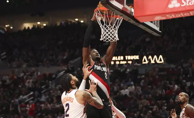 Portland Trail Blazers center Deandre Ayton (2) dunks over Phoenix Suns center Nick Richards (2) during the first half of an NBA basketball game Saturday, Feb. 1, 2025, in Portland, Ore. (AP Photo/Amanda Loman)