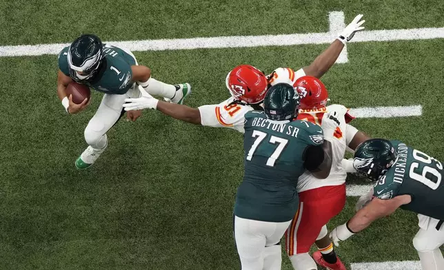 Philadelphia Eagles quarterback Jalen Hurts (1) evades pressure from Kansas City Chiefs defensive tackle Derrick Nnadi (91) during the first half of the NFL Super Bowl 59 football game, Sunday, Feb. 9, 2025, in New Orleans. (AP Photo/Godofredo A. Vásquez)