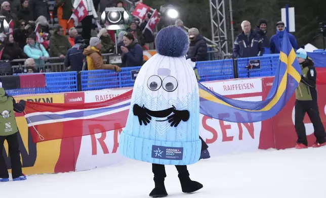The mascot of 2026 Ski World Championship is seen at the finish line prior to an alpine ski, men's World Cup downhill, in Crans Montana, Switzerland, Saturday, Feb. 22, 2025. (AP Photo/Giovanni Auletta)